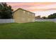 Expansive backyard features lush green grass, and a white privacy fence at 670 Bluebill Ct, Poinciana, FL 34759