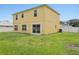 Rear exterior view of home, highlighting the yard, sliding glass door and fenced yard at 670 Bluebill Ct, Poinciana, FL 34759