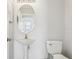 Small bathroom with a pedestal sink and a toilet at 670 Bluebill Ct, Poinciana, FL 34759