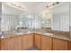 Bathroom featuring double sinks, granite countertops, and a large mirror at 670 Bluebill Ct, Poinciana, FL 34759