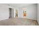 Spacious bedroom with neutral carpeting, gray walls, closet, and access to the adjacent bathroom at 670 Bluebill Ct, Poinciana, FL 34759