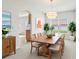Airy dining room with long wooden table, chandelier, and neutral color palette at 670 Bluebill Ct, Poinciana, FL 34759