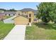 Well-maintained two-story home with attached garage, driveway, and a green lawn at 670 Bluebill Ct, Poinciana, FL 34759