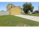 Exterior shot of a two-story home with an attached two car garage, a spacious driveway and a green lawn at 670 Bluebill Ct, Poinciana, FL 34759