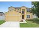 Charming two-story home featuring a well-kept lawn, attached garage, and inviting front entrance at 670 Bluebill Ct, Poinciana, FL 34759
