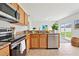 Well-lit kitchen featuring granite countertops, stainless steel appliances, and a sliding glass door at 670 Bluebill Ct, Poinciana, FL 34759