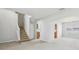 View of carpeted living room with staircase and arched doorway to kitchen at 670 Bluebill Ct, Poinciana, FL 34759
