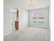 View of carpeted living room and chandelier with arched doorway to kitchen at 670 Bluebill Ct, Poinciana, FL 34759
