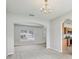 View of carpeted living room with chandelier and arched doorway to kitchen at 670 Bluebill Ct, Poinciana, FL 34759