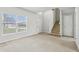 Bright, carpeted living room featuring a large window and staircase at 670 Bluebill Ct, Poinciana, FL 34759