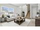 Bright living room with modern decor, plush sofa, stylish coffee table, and staircase at 670 Bluebill Ct, Poinciana, FL 34759