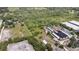 Aerial view showcases land, greenhouses, a pond, and some buildings at 6957 Plymouth Sorrento Rd, Apopka, FL 32712