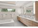 Bathroom with a long double vanity, modern tub, and an oversized window at 7 Ne Ivanhoe Blvd, Orlando, FL 32804