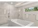 Modern bathroom featuring soaking tub with glass shower and marble floors at 7 Ne Ivanhoe Blvd, Orlando, FL 32804