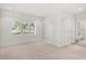 Bright bedroom featuring neutral carpet, plantation shutters, built-in shelving and cabinets, and access to the bath at 7 Ne Ivanhoe Blvd, Orlando, FL 32804
