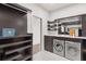 A modern laundry room featuring a washer, dryer, custom shelving, and luxury accessories, offers style and utility at 7 Ne Ivanhoe Blvd, Orlando, FL 32804