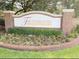 Community entrance sign with brick pillars, manicured landscaping, and colorful flowers at 725 Ashworth Overlook Dr # C, Apopka, FL 32712
