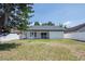 Large backyard with lawn, mature tree, and white fencing at 7646 Coconut Creek Ct, Orlando, FL 32822