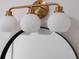 Stylish bathroom lighting fixture with round shades and gold finish at 7646 Coconut Creek Ct, Orlando, FL 32822