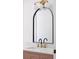 Arched mirror and elegant vanity with brass fixtures provide modern elegance at 7646 Coconut Creek Ct, Orlando, FL 32822