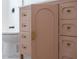 Pink bathroom vanity with gold hardware and arched door and drawer fronts at 7646 Coconut Creek Ct, Orlando, FL 32822