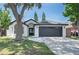 Charming single-story home with a two-car garage, classic white paint, and lovely yard with mature trees at 7646 Coconut Creek Ct, Orlando, FL 32822