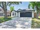 View of a bright white, single-story home with a two-car garage and a well-manicured lawn at 7646 Coconut Creek Ct, Orlando, FL 32822