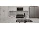 View of the kitchen sink, marble backsplash, cabinets and counters, and stainless steel appliances at 7646 Coconut Creek Ct, Orlando, FL 32822