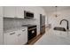 A modern kitchen featuring stainless steel appliances and white cabinets with marble countertops and backsplash at 7646 Coconut Creek Ct, Orlando, FL 32822