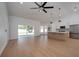 Bright living room with wood floors, a ceiling fan, and kitchen featuring an island with marble countertops at 7646 Coconut Creek Ct, Orlando, FL 32822