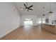 A large living room with wood floors and ceiling fan that flows into the kitchen with an island at 7646 Coconut Creek Ct, Orlando, FL 32822