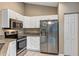 Modern kitchen featuring white cabinets, granite counters, stainless steel appliances and tile flooring at 8 Water Trce, Ocala, FL 34472