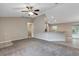 Open living room features neutral paint, carpet flooring, a view into the kitchen, and natural light at 8 Water Trce, Ocala, FL 34472