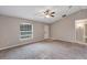 Open living room features neutral paint, carpet flooring, a front door, and a window with mini blinds at 8 Water Trce, Ocala, FL 34472