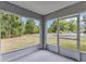 View from the screened porch to the backyard with green grass and scattered trees at 8 Water Trce, Ocala, FL 34472