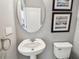 Cozy bathroom featuring a pedestal sink, framed art, and a white toilet at 811 Sherbourne Cir, Lake Mary, FL 32746