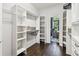 Custom walk-in closet with built-in shelving, wood flooring, and a view of the bedroom at 811 Sherbourne Cir, Lake Mary, FL 32746