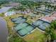 Aerial shot featuring the community pool, tennis courts and gym amenities by a lake at 811 Sherbourne Cir, Lake Mary, FL 32746