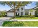 Charming two-story home featuring a well-manicured lawn, mature trees, and a two-car garage at 811 Sherbourne Cir, Lake Mary, FL 32746