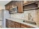 Kitchenette featuring dark wood cabinets, granite countertops, and stainless steel appliances at 811 Sherbourne Cir, Lake Mary, FL 32746