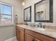 Bathroom featuring double sinks with granite countertop and decorative framed mirrors and a window providing natural light at 1010 Juliette Blvd, Mount Dora, FL 32757