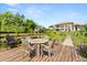 Wooden deck features an outdoor dining table and a view of the backyard at 1010 Juliette Blvd, Mount Dora, FL 32757