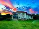 Beautiful two-story home with lush green lawn and vibrant sunset sky views at 1010 Juliette Blvd, Mount Dora, FL 32757
