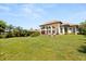 Sprawling backyard with lush lawn and impressive house in the background at 1010 Juliette Blvd, Mount Dora, FL 32757