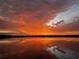 Picturesque lake view at sunset, showcasing red and orange colors with cloud reflections at 1010 Juliette Blvd, Mount Dora, FL 32757