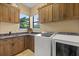 Laundry room featuring wooden cabinetry, a sink, counter space and modern washer and dryer units at 1010 Juliette Blvd, Mount Dora, FL 32757