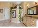 Serene bathroom featuring a vanity with granite countertops, decorative plants and a large mirror at 1010 Juliette Blvd, Mount Dora, FL 32757