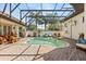 Enclosed pool and spa area with brick patio, landscaping, and outdoor furniture for relaxing and entertaining at 1010 Juliette Blvd, Mount Dora, FL 32757