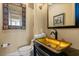 Stylish powder room featuring a gold vessel sink, decorative mirror, and a modern faucet at 1010 Juliette Blvd, Mount Dora, FL 32757