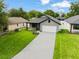 Aerial view of a single Gathering home with a gray roof, brick driveway, and a well-manicured lawn at 1113 Naples Dr, Orlando, FL 32804